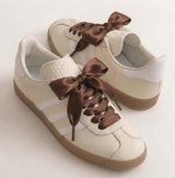 Lacets satin marron sur des baskets crème
