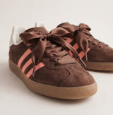 Lacets ruban satin marron noués sur des baskets en daim marron